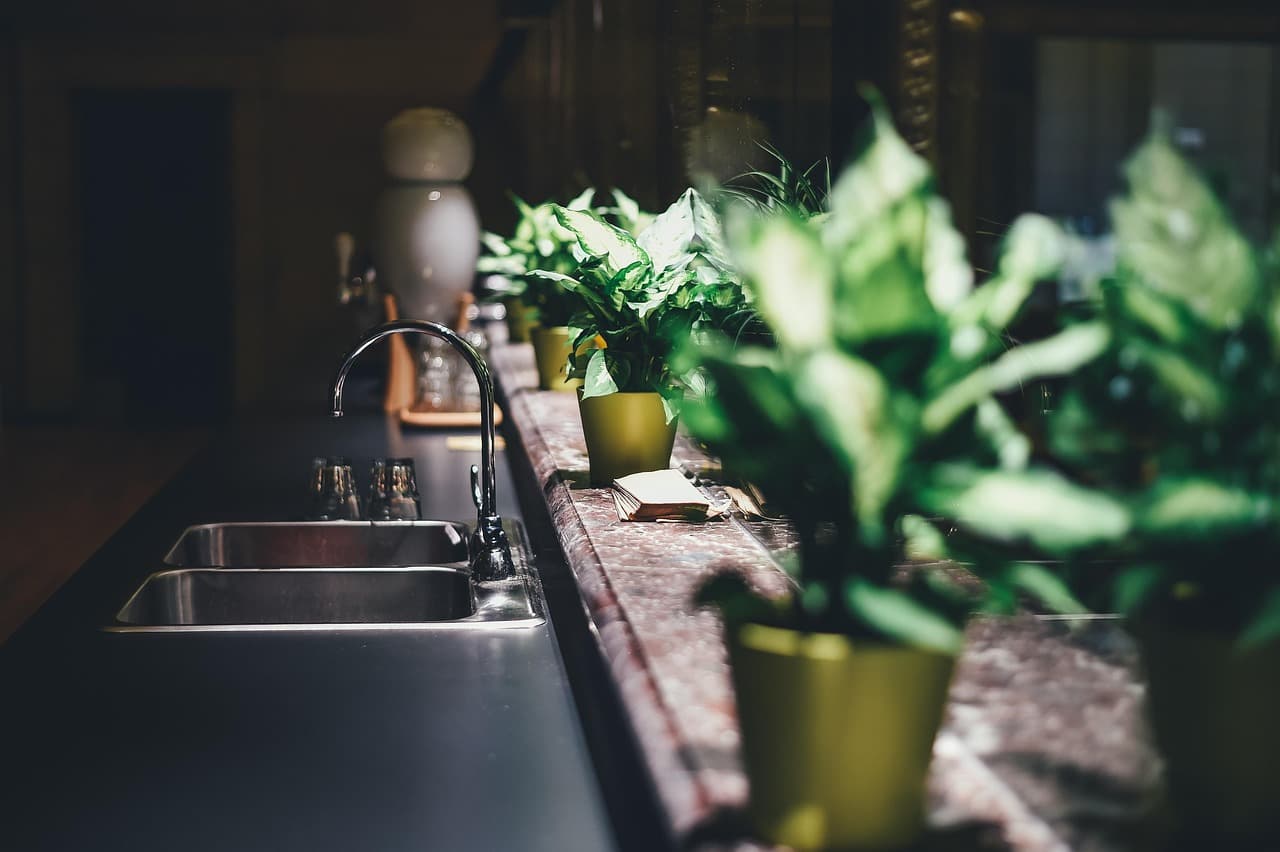 Stainless steel kitchen mixer tap installed above a modern sink